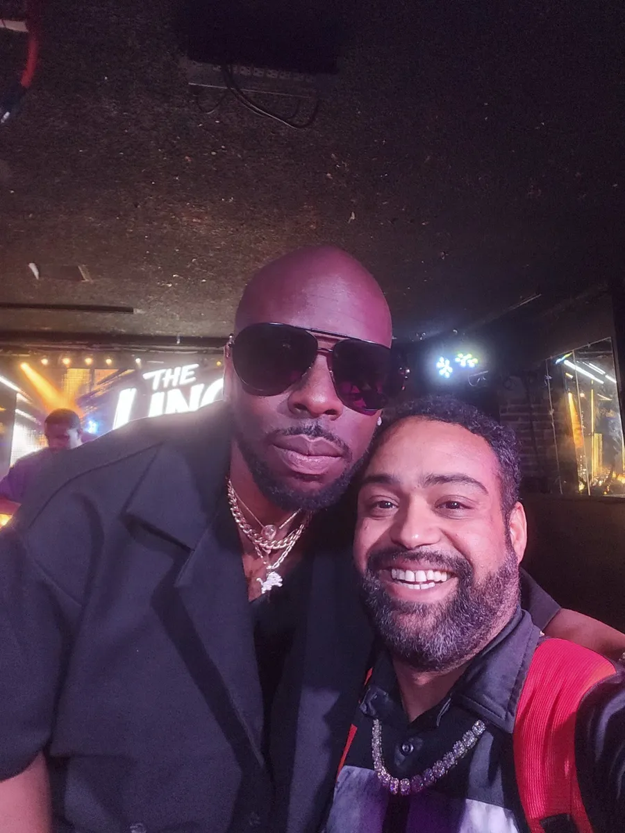 JC grinning in a selfie beside a taller guest in sunglasses at a BET weekend event