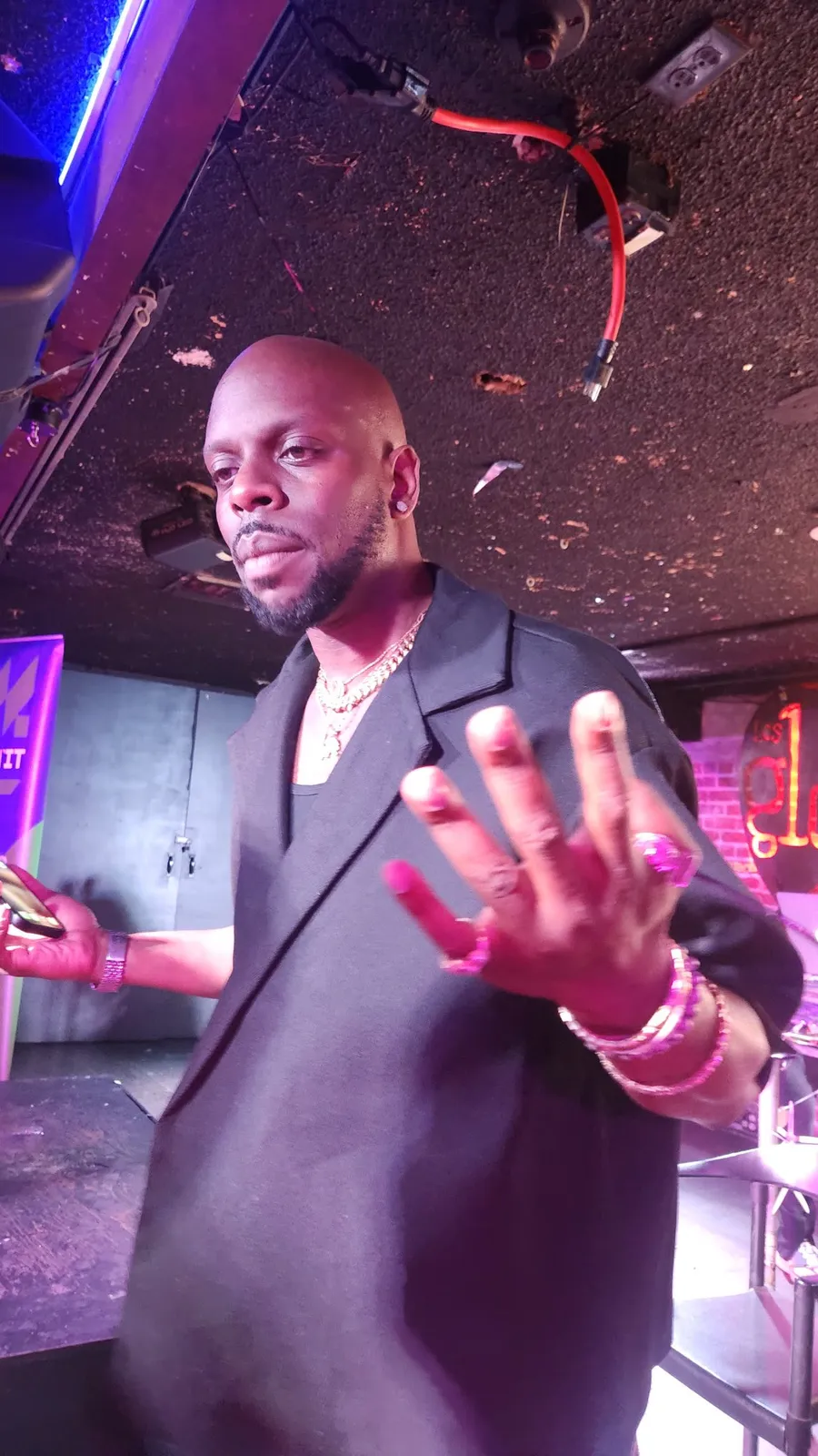 A guest in a black blazer gesturing mid-conversation at a BET weekend event, a MAKIN IT banner at the edge of the frame